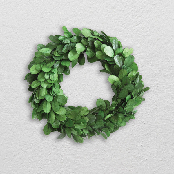 A circular preserved boxwood wreath with deep green leaves, handcrafted and intended for indoor use.
